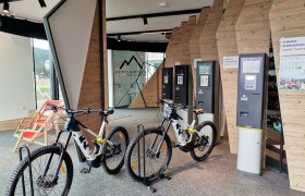 E-MTB Verleih im Servicecenter Erlebnisalm, © Wiener Alpen Innenansicht eines E-MTB Verleihs mit Fahrrädern und Ticketautomaten.