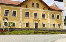 Villa Luef, © Ildiko Davidne Nagy Gelbes Gebäude mit der Aufschrift 'Villa Luef', umgeben von einem Zaun und einer Straße im Vordergrund.