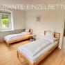 Schlafzimmer, © Christoph Menhofer Schlafzimmer mit zwei Einzelbetten, Holzboden und Fenster mit Blick nach draußen.