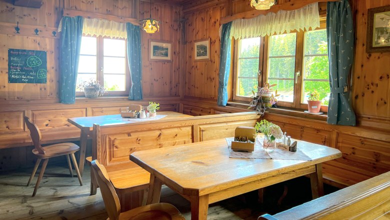 Gemütliche Stube, © www.designorita.at Gemütliche Stube mit Holzmöbeln, blauen Vorhängen und Pflanzen auf den Tischen.