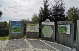 Wanderstartplatz, © Wiener Alpen Informationstafeln am Wanderstartplatz in Mönichkirchen mit Karten und Hinweisen, umgeben von Bäumen.