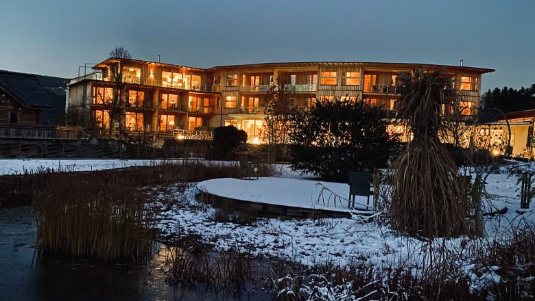 Naturhotel Molzbachhof, © PeterPichler Beleuchtetes Hotel in winterlicher Landschaft bei Dämmerung.