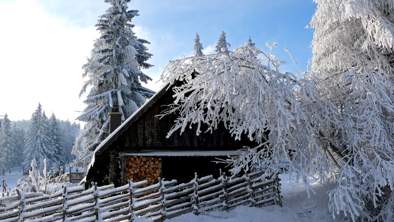 Winter in Mönichkirchen, © Wiener Alpen/Franz Zwickl Verschneite Hütte in Mönichkirchen mit schneebedeckten Bäumen und Zaun.