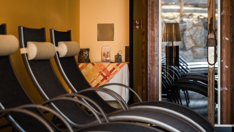 Innenansicht eines Ruheraums mit Liegestühlen und einem Tisch mit Tischdecke.