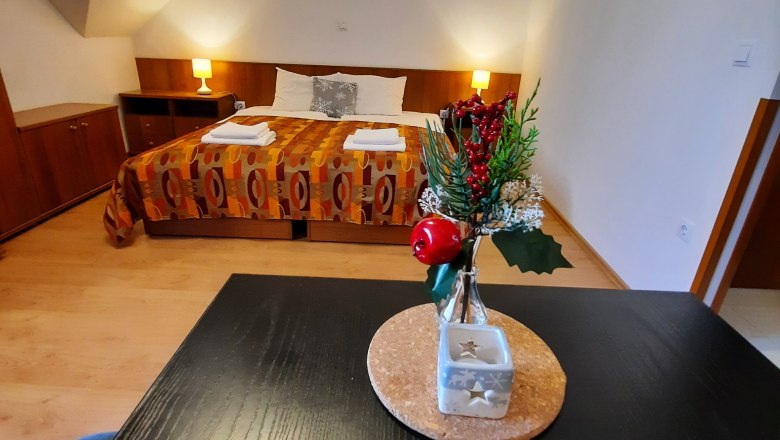 Ein gemütliches Doppelzimmer mit einem dekorierten Tisch im Vordergrund und einem Bett im Hintergrund.