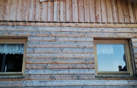 Holzh&uuml;tte mit der Aufschrift 'Sumpihittn #2' &uuml;ber den Fenstern.