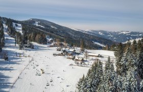 Winterlandschaft mit Skilift und verschneiten Bergen in Mönichkirchen.