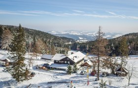Winterlandschaft mit Berggasthof und Skilift in Mönichkirchen.