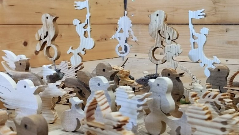 Holzfiguren in Tier- und Menschenform auf einem Holztisch.