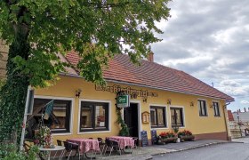 Au&szlig;enansicht eines traditionellen Gasthauses mit gelber Fassade und roten Dachziegeln.