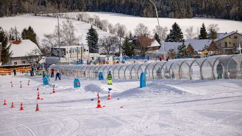 Skischule in St. Corona am Wechsel mit Kindern auf der Piste und Förderband.