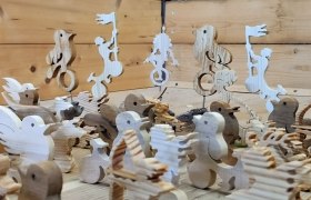 Holzfiguren in Tier- und Menschenform auf einem Holztisch.