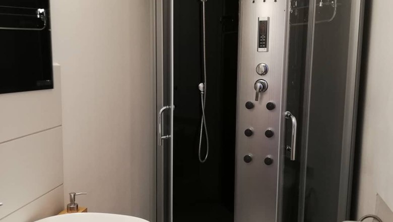 Modernes Badezimmer mit Duschkabine, Waschbecken und Toilette.