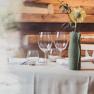 Eleganter Restauranttisch mit Gläsern und Blume in Vase.