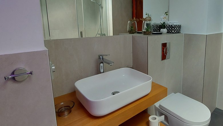 Modernes Badezimmer mit Waschbecken, Toilette und Dusche.