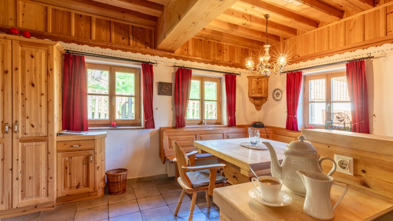 Essbereich in traditionellem Stil mit Holzmöbeln und roten Vorhängen.