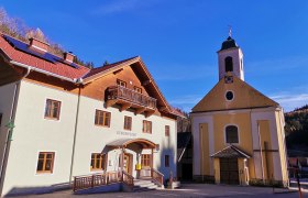 Gemeindeamt und Kirche in Trattenbach bei sonnigem Wetter.