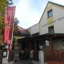 Eingang des Gasthofs Grüner Baum mit rotem Banner und Willkommensschild.