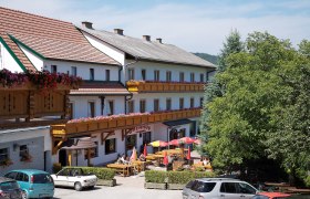 Gasthof-Pension &Ouml;denhof mit Terrasse und geparkten Autos.