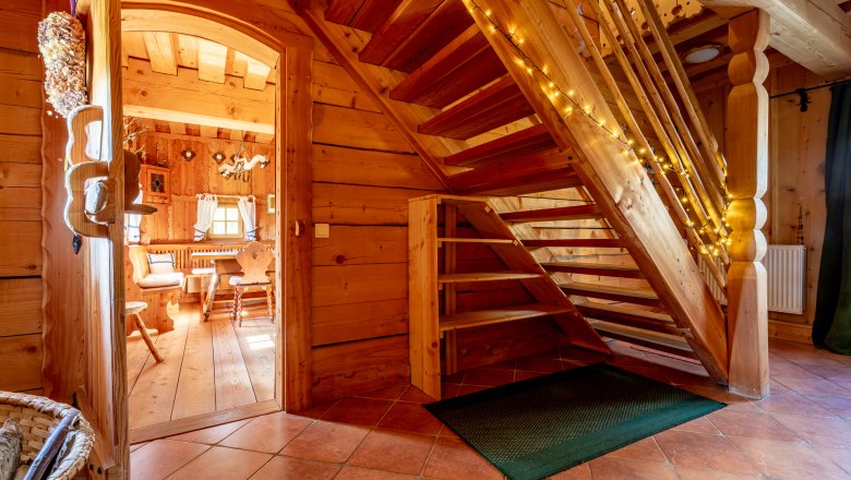 Holztreppe in einem Haum mit Holzvertäfelung mit Lichterkette dekoriert.