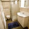 Badezimmer mit Dusche, Waschbecken, WC und Handtuchheizkörper.