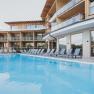 Modernes Hotel mit Pool und Liegestühlen im Freien.