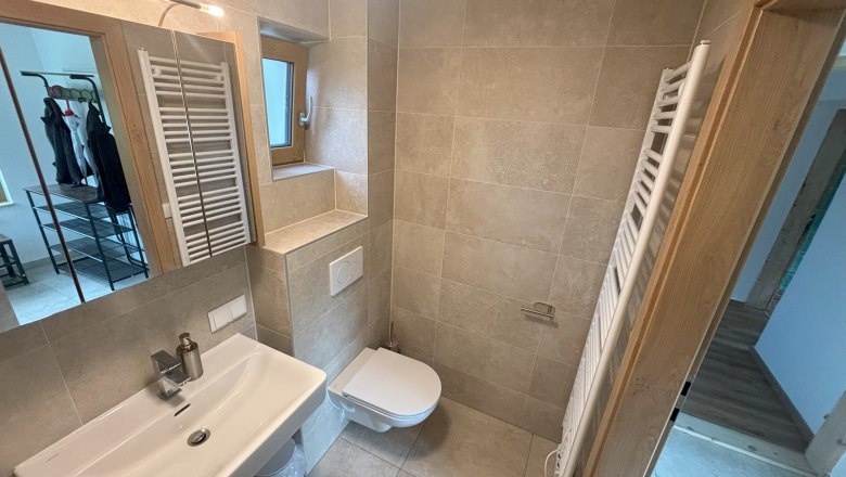 Modernes Badezimmer mit Waschbecken, WC und Handtuchheizk&ouml;rper.