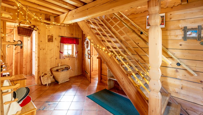 Raum mit Holzvertäfelung, Fliesenboden, einer Treppe und Dekoration.