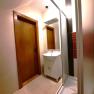 Modernes Badezimmer mit Holzt&uuml;r, Waschbecken und Dusche.