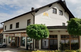 Au&szlig;enansicht der B&auml;ckerei Dorfstetter mit B&auml;umen davor.