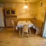Essbereich in einem rustikalen Ferienhaus mit Holzmöbeln und Eckbank.