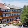 Gasthof-Pension Ödenhof mit Terrasse und geparkten Autos.